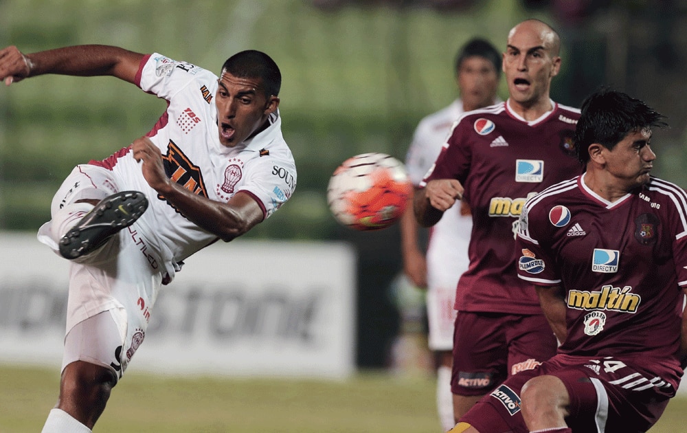 Mauro Bogado of Argentina's Huracan kicks the ball past William Diaz of Venezuela's Caracas FC during their Copa Libertadores soccer match in Caracas.