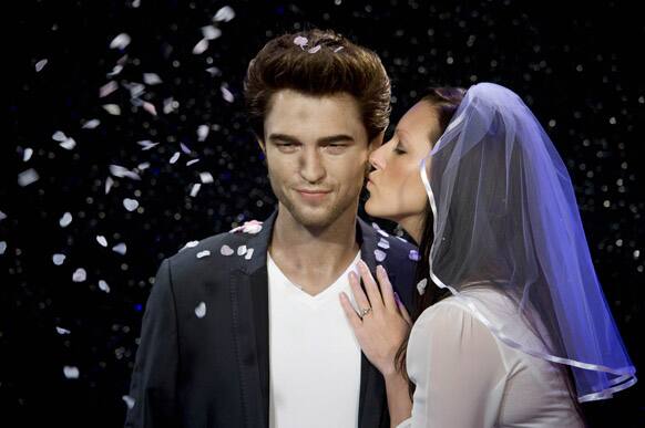 The waxwork of British actor Robert Pattinson, left, at Madame Tussauds London, is kissed by mock bride Hayley Wales.