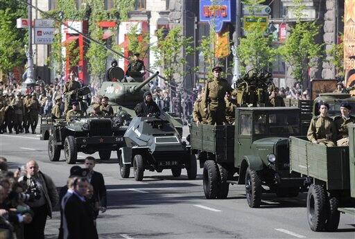 Ukrainian soldiers dressed in Soviet-era uniforms ride in military vehicles during the Victory Day in Kiev.