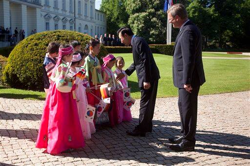 German President Christian Wulff and South Korean President Lee Myung-bak greet school girls in traditional Korean costumes during the welcoming ceremony at Bellevue Palace in Berlin.