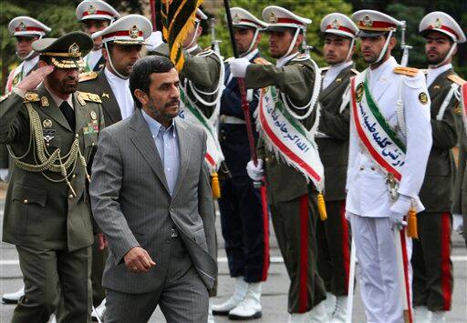 Iranian President Mahmoud Ahmadinejad, second left, reviews an honor guard during a departure ceremony for him as he leaves for Turkey to attend an international conference at Mehrabad airport in Tehran.