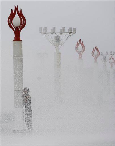 A man hides behind a post as strong waves batter Manila`s bay, Philippines. Tropical storm Aere threatened the Philippines` agricultural north Monday after pummeling the eastern coast and the capital with fierce winds and rain that sparked floods and landslides