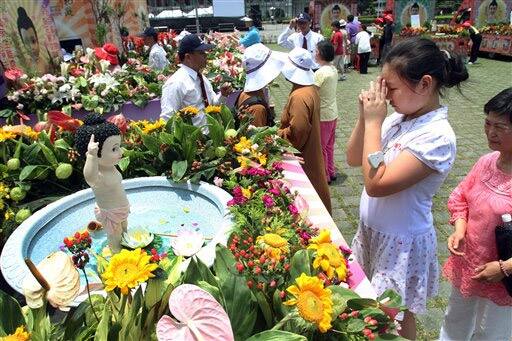 A Taiwanese girl prays after washing a statue of baby Buddha on Taiwan`s national Buddha`s birthday in Taipei.