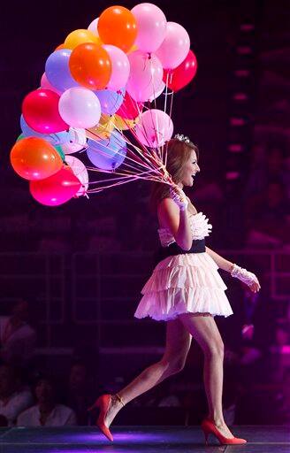 Japanese artist Reika Hashimoto holds balloons while showcasing fashion produced by Honey`s closet during the Tokyo Girls Collection fashion show held in Beijing.