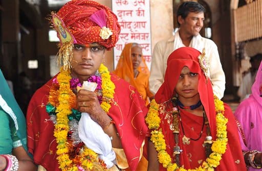 Raja,16, and 15-year-old child bride Sintu look on at the Balaji temple in Kamkheda village, in the western Indian state of Rajasthan.