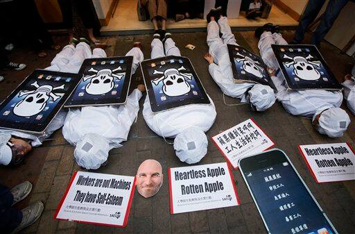 Local and mainland Chinese university students, dressed as the Foxconn workers and wearing mock iPad with a skeleton print as they try to block the customers at an Apple Premium Reseller shop in Hong Kong. They denounced Apple Inc. and its Chinese supplier Foxconn Technology Group for the alleged dire working conditions of their workers.