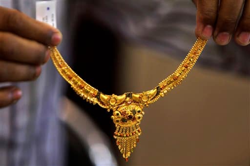 An Indian salesman displays a gold necklace as people shop for gold jewelry in Jammu. Friday marks Hindu festival 