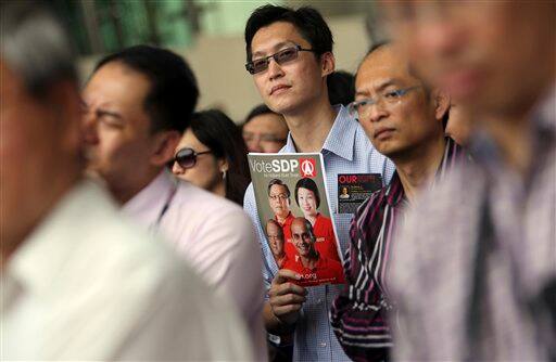 A supporter of the opposition Singapore Democratic Party holds a campaign booklet during a rally in the financial district in Singapore.