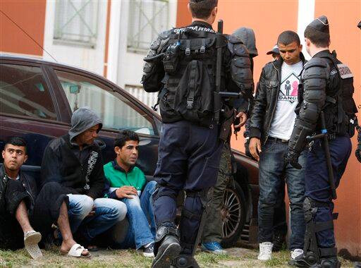 Tunisian migrants coming from Italy are watched by French policemen at a worker`s residence after being detained in Nice, southern France. Many of the Tunisian migrants are looking to move to France, and their influx has strained relations between the two European Union member states.