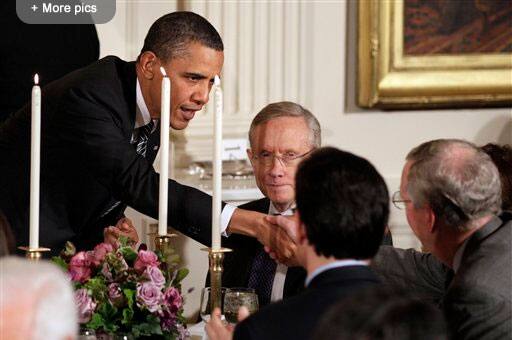 President Barack Obama reaches across the table to shake hands with Senate Minority Leader Mitch McConnell of Ky., as Senate Majority Leader Harry Reid of Nev., second from left, and House Majority Leader Eric Cantor of Va., back to the camera, during a dinner for a group of bipartisan Congressional leaders and ranking members and their spouses at the White House in Washington.