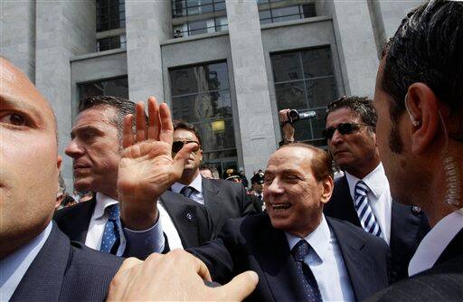 Italian Premier Silvio Berlusconi, surrounded by his body guards, greets supporters after attending a hearing in his Mediatrade trial at Milan`s courthouse, Italy.