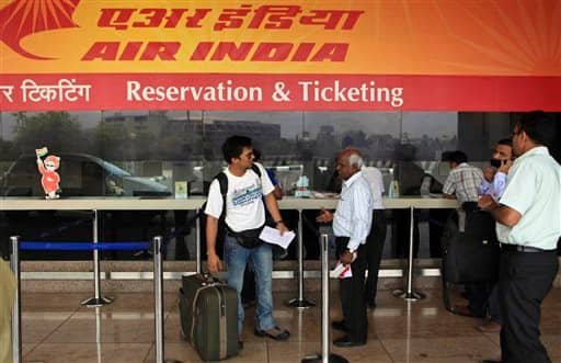 A passenger talks to another as their flights got canceled at an Air India ticket counter at the domestic airport in Mumbai.