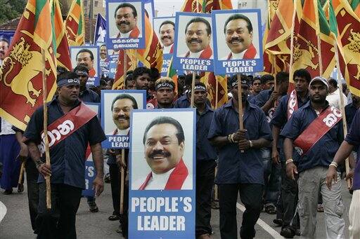 Supporters of Sri Lankan President Mahinda Rajapakse hold his posters during a May Day rally in Colombo.