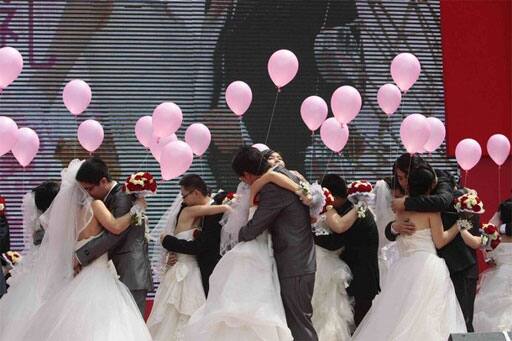 Couples hug during a mass wedding ceremony at a square in Nanjing, Jiangsu province May 1, 2011. The mass wedding ceremony was held for 52 couples on Sunday as part of May Day celebrations, local media reported.