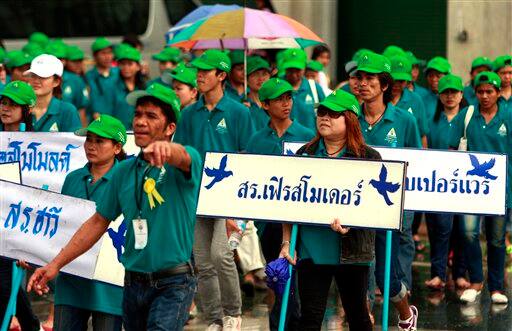 Thai workers march on the ground of the Bangkok metropolitan administration office with placards of their representatives during May Day celebrations Sunday, May 1, 2011 in Bangkok.