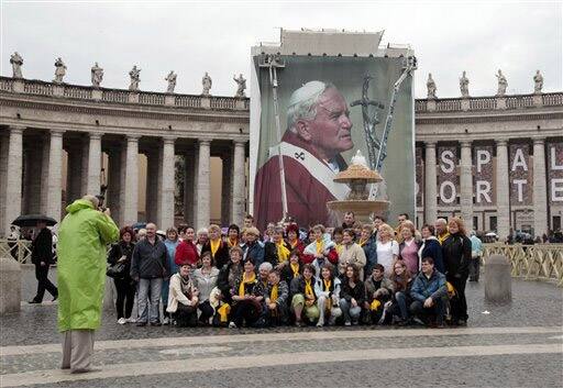 Pilgrims from Rzeszow Czudec, Poland, pose in front of a giant photograph of the late Pope John Paul II set up in St. Peter`s Square, at the Vatican.