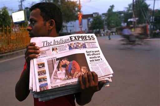 A vendors carries newspapers for distribution with front pages showing the photos of royal wedding of Britain`s Prince William and Kate Middleton.