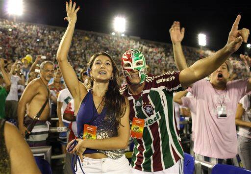 A man wearing a Mexican Lucha Libre mask watches the Imperatriz Leopoldinense samba school parade in the Sambadrome during Carnival celebrations in Rio de Janeiro, Brazil.