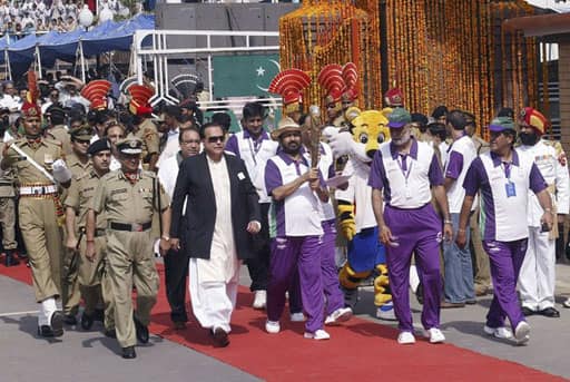 President of the Indian Olympic Association (IOA) Suresh Kalmadi holds the Queen`s Baton during the XIX Commonwealth Games Queen`s Baton Relay as Pakistani Punjab Governor Salman Taseer (in black coat) walk along with other officials at the India-Pakistan joint check-post at the Wagah border June 25, 2010. The Baton arrived in India from Pakistan on Friday. The Baton is carried through several Commonwealth countries in the run up to the Delhi 2010 Commonwealth Games in October 2010.