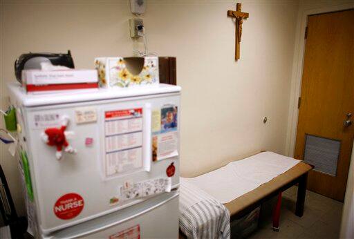 A crucifix hangs above a bed in the nurse`s office at St. Francis Prep high school in the Queens borough of New York. St. Francis Prep was closed for a week earlier this year after an outbreak of swine flu in New York was linked to the school.