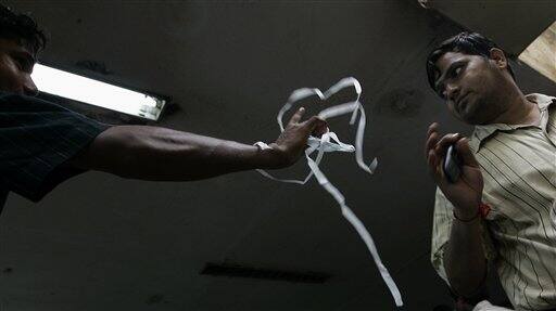 A vendor sells surgical masks that are gaining popularity as preventive use against swine flu, outside a local train station in Mumbai, India, Wednesday, Aug. 12, 2009. Authorities ordered the closure of all schools and movie theaters in Mumbai on Wednesday, as the number of swine flu fatalities in the country rose to 15, officials and news reports said.