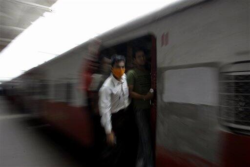 A commuter on a local train wears a mask as a preventive measure against swine flu in Mumbai, India, Wednesday, Aug. 12, 2009. Authorities ordered the closure of all schools and movie theaters in Mumbai on Wednesday, as the number of swine flu fatalities in the country rose to 15, officials and news reports said.