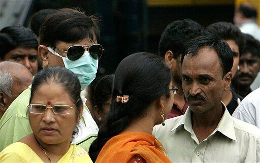 A man wearing a protective mask is seen on a crowded street in Mumbai, India, Tuesday, Aug. 11, 2009. The country-wide death toll due to swine flu related virus has gone up to 10, a news agency reported.