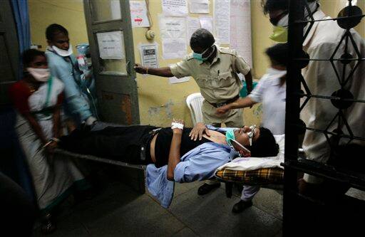 A suspected swine flu patient lies on a stretcher before being transferred from Naidu hospital to Sassoon hospital in Pune, India, Tuesday, Aug. 11, 2009. The country-wide death toll due to swine flu related virus has gone up to 10, a news agency reported.