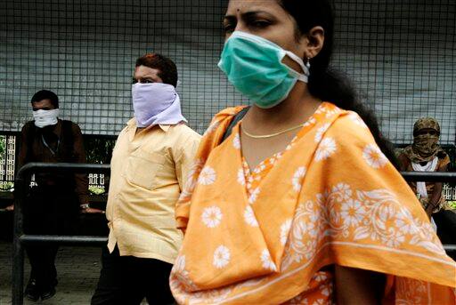 Commuters cover their faces as a preventive measure against swine flu in Pune, India, Tuesday, Aug. 11, 2009. The country-wide death toll of swine flu related deaths has risen to 10, a news agency reported.