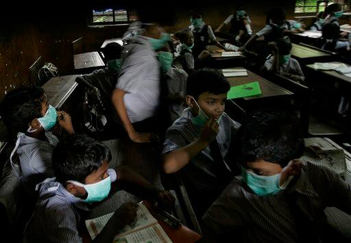 Children wearing masks sit in their classroom, in Mumbai, India, Monday, Aug. 10, 2009. A regional party, the Shiv Sena distributed masks in schools as a preventive measure against swine flu. According to media reports, two more people infected with swine flu have died, raising the country`s death toll from the virus to six.