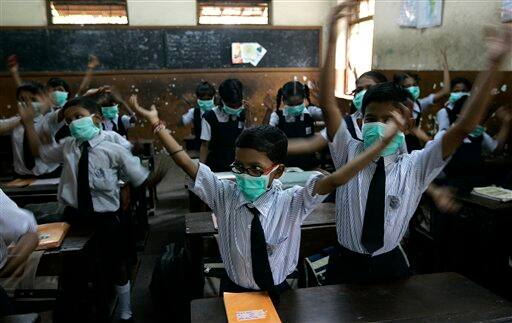 Children wearing masks, sing in their classroom, in Mumbai, India, Monday, Aug. 10, 2009. A regional party, the Shiv Sena distributed masks in schools as a preventive measure against swine flu. According to media reports, two more people infected with swine flu have died, raising the country`s death toll from the virus to six.