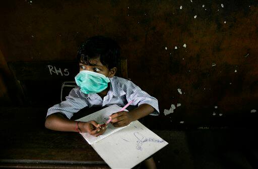 A boy wearing a mask sits in a classroom, in Mumbai, India, Monday, Aug. 10, 2009. A regional party, the Shiv Sena distributed masks in schools as a preventive measure against swine flu. According to media reports, two more people infected with swine flu have died, raising the country`s death toll from the virus to six.