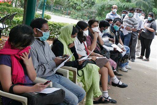 People wait to get themselves examined at a swine flu examination center at a government hospital in Bangalore, India, Monday, Aug. 10, 2009. According to media reports, two more people infected with swine flu have died, raising the country`s death toll from the virus to six.