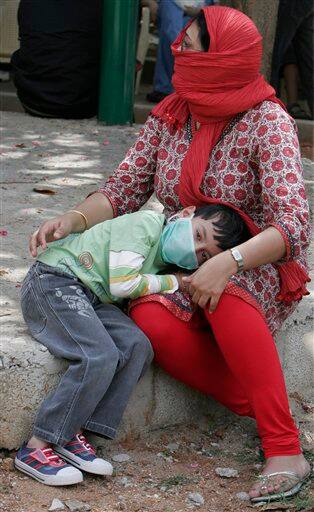 A child rests on his mother`s lap as he waits to get himself examined for H1N1 virus at a swine flu examination center at a government hospital in Bangalore, India, Monday, Aug. 10, 2009. According to media reports, two more people infected with swine flu have died, raising the country`s death toll from the virus to six.