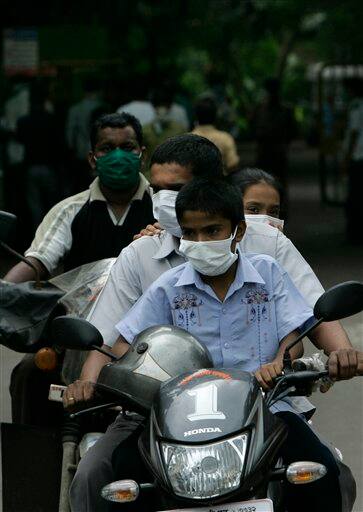 People return after swine flu examination at Kasturba Gandhi hospital in Mumbai, India, Sunday, Aug. 9, 2009. Indian media is reporting that three more people infected with swine flu have died, raising the country`s death toll from the virus to four.