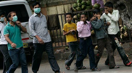 Young boys react as they pass by Kasturba Gandhi hospital where swine flu patients are being tested and treated, in Mumbai, India, Sunday, Aug. 9, 2009. Indian media is reporting that three more people infected with swine flu have died, raising the country`s death toll from the virus to four.