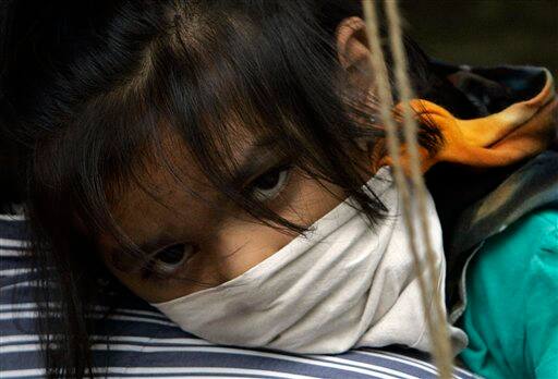 A man carries a girl for swine flu examination at Kasturba Gandhi hospital in Mumbai, India, Sunday, Aug. 9, 2009. Indian media is reporting that three more people infected with swine flu have died, raising the country`s death toll from the virus to four.