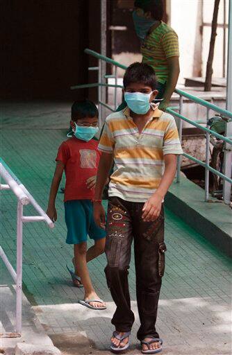 Children wearing respiratory masks are seen outside a H1N1 Swine flu examination center at a government hospital in New Delhi, India, Sunday, Aug. 9, 2009. Media reports say three more people infected with swine flu have died in India, raising the country`s death toll related to the virus to four.