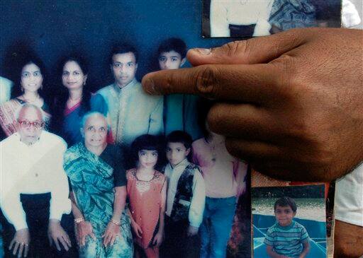 A relative puts his index finger on an undated family photograph to identify non-resident Indian Pravin Patel who died of swine flu in Ahmadabad, India, Sunday, Aug. 9, 2009. Patel, a 43-year-old who arrived in the city from Atlanta on July 31, died of swine flu early Sunday, a senior official said. With two deaths reported from Pune and one in Mumbai, Patel`s is the country`s fourth swine flu fatality according to news reports.