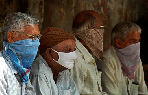 Neighbors wears masks as they mourn the death of non-resident Indian Pravin Patel who died of swine flu in Ahmadabad, India, Sunday, Aug. 9, 2009. Patel, a 43-year-old who arrived in the city from Atlanta on July 31, died of swine flu early Sunday, a senior official said. With two deaths reported from Pune and one in Mumbai, Patel`s is the country`s fourth swine flu fatality according to news reports.