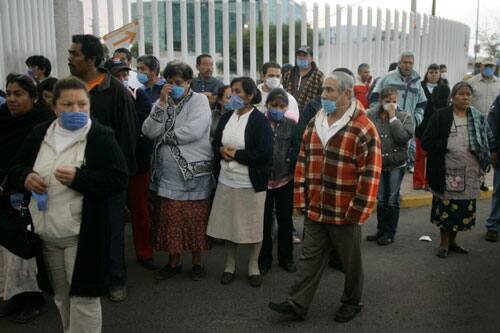 People wearing protective face masks stand outside a hospital in Toluca, Mexico, Sunday, April 26, 2009.