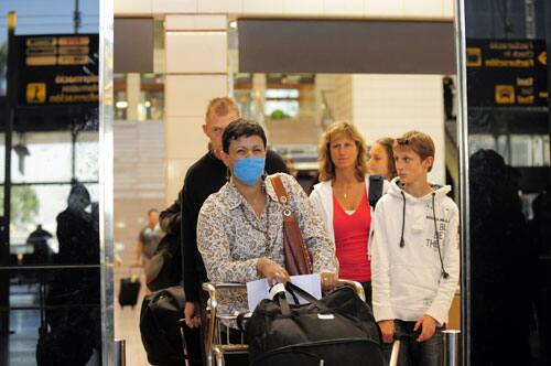 An airline passenger from Mexico wearing a face mask arrives at the Barcelona Airport in Barcelona, Spain, Monday, April 27, 2009.