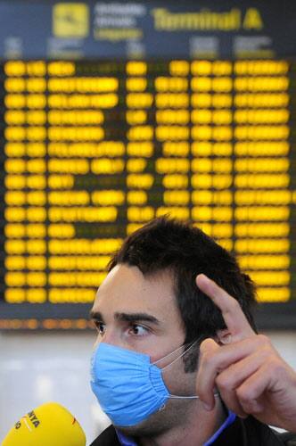 An airline passenger wearing a face mask arrives from Mexico at the airport in Barcelona, Spain, Monday, April 27, 2009. 