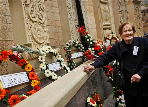 Survivior Mary Kevorkian leans against a monument following a prayer marking the 94th anniversary of the mass killing of the Armenian people, next to St. James Cathedral in the Armenian Quarter of Jerusalem`s Old City