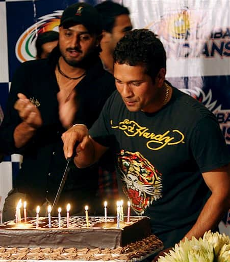 Indian cricketer Sachin Tendulkar, right, cuts his birthday cake as he celebrates his 36th birthday with teammate Harbhajan Singh, left, in Durban