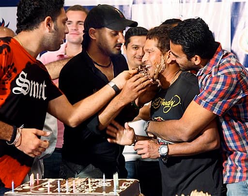 Indian cricketers Yuvraj Singh, left, Harbhajan Singh, second left, and Zaheer Khan, right, smear cake on the face of fellow player Sachin Tendulkar on Tendulkar’s 36th birthday celebrations in Durban