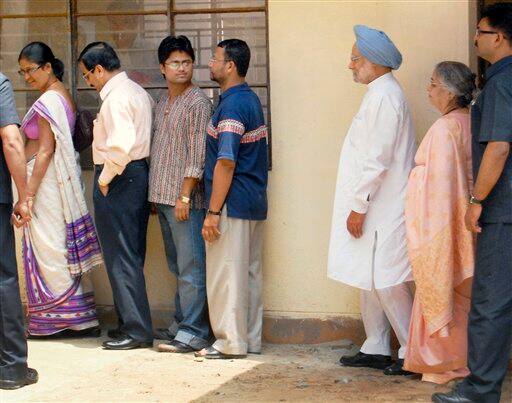 Indian Prime Minister Manmohan Singh, third right, accompanied by wife Gursharan Kaur, second right, stands in queue to cast his vote for the Lok Sabha elections in Gauhati.