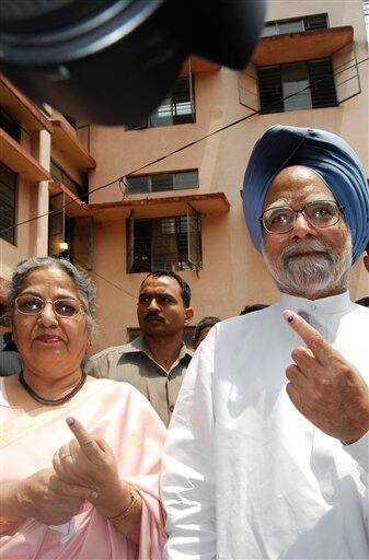 Indian Prime Minister Manmohan Singh and wife Gursharan Kaur show their marked fingers to media after casting their votes in Gauhati