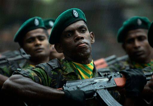 Sri Lankan police commandos march in the rain during a passing out ceremony of 177 officers at their training college in Kalutara, about 30 kilometers (19 miles) south of capital Colombo, Sri Lanka. An international rights group on Friday urged Sri Lanka`s military to stop firing artillery into a designated 