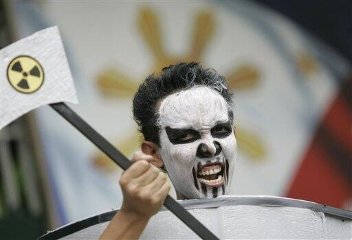 An activists holding a nuclear power sign shouts slogans outside the Department of Environment and Natural Resources headquarters in suburban Quezon City, North of Manila, Philippines